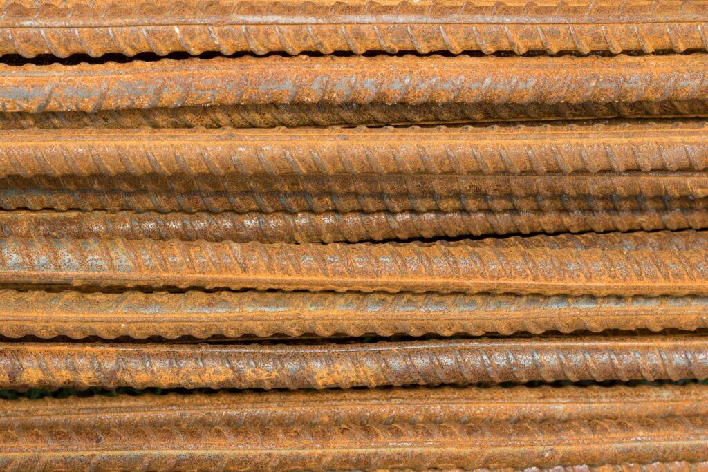 Rusted rebar is stacked horizontally.